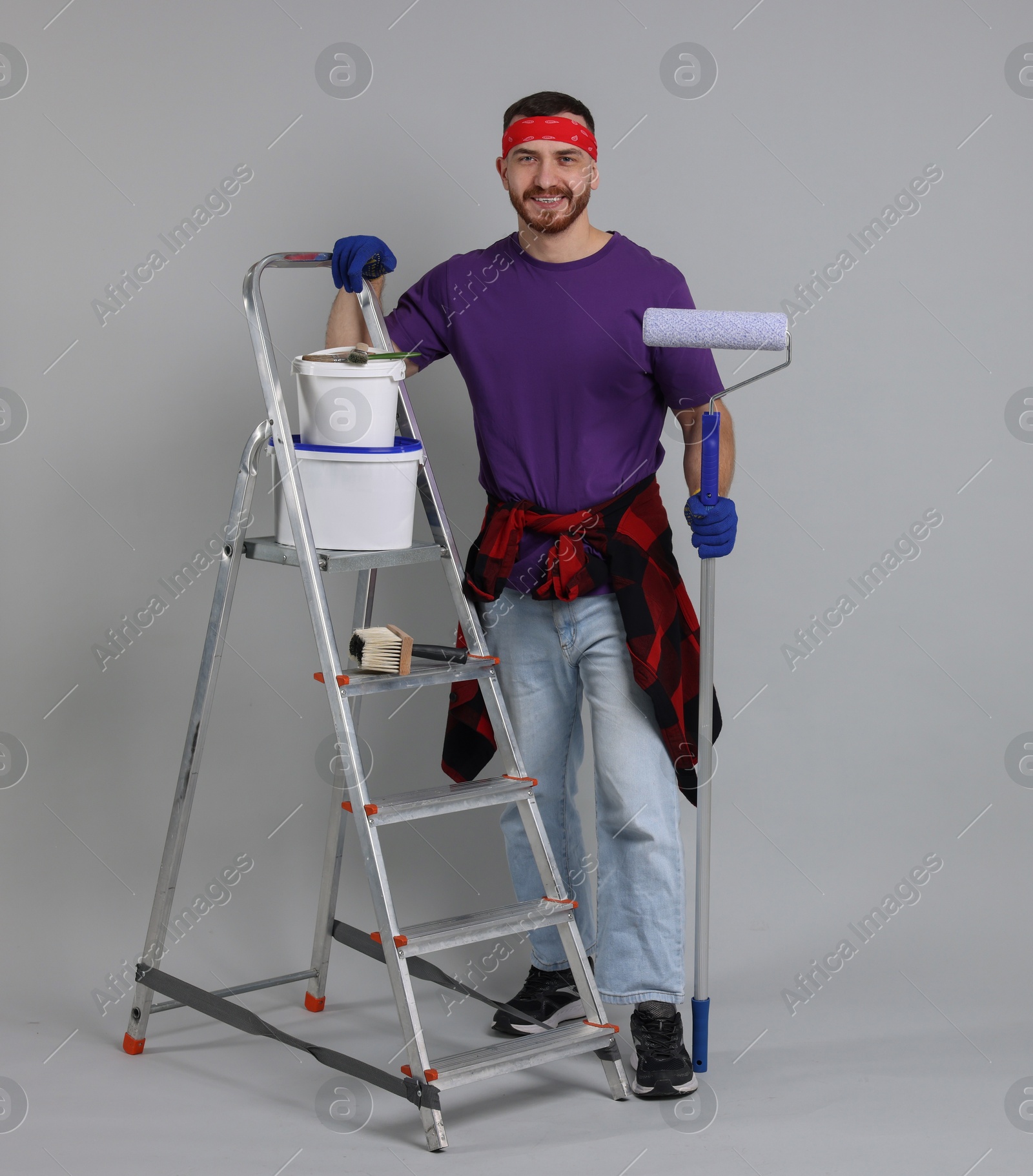 Photo of Man with tools and supplies on light grey background