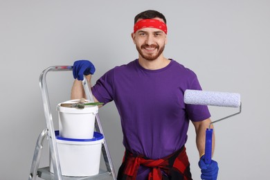 Photo of Man with tools and supplies on light grey background