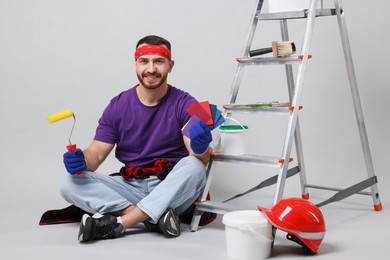 Photo of Man with tools and supplies on light grey background