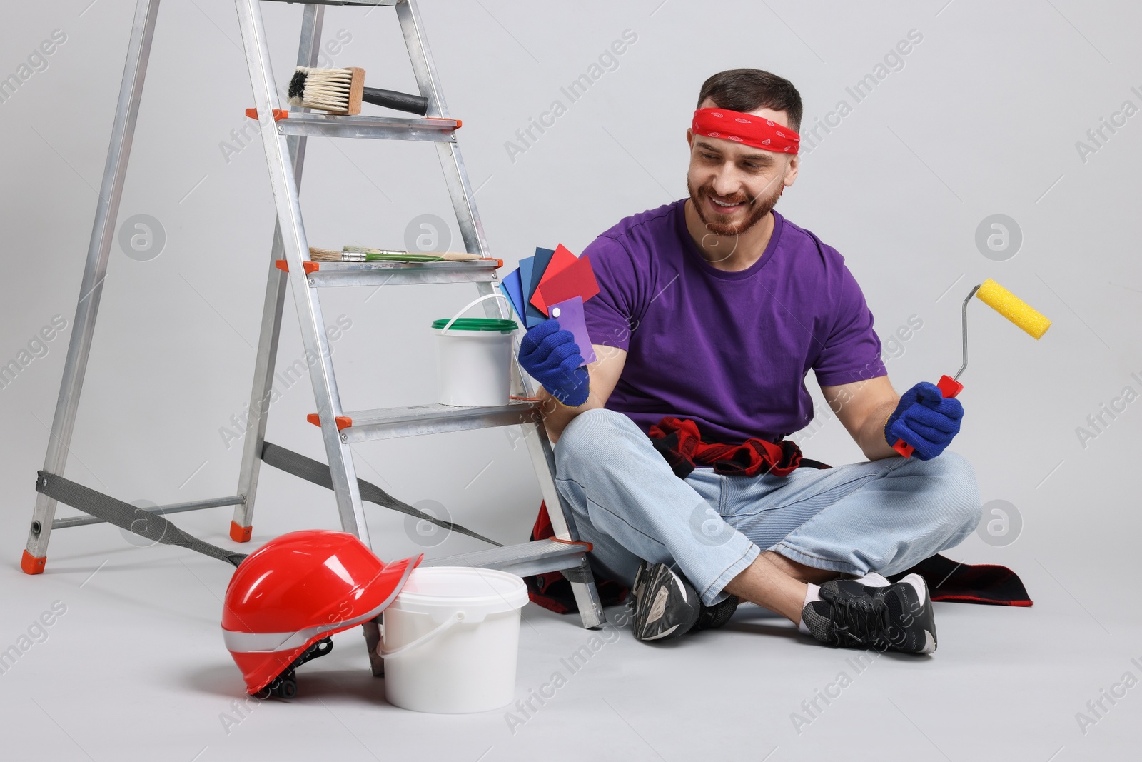 Photo of Man with tools and supplies on light grey background