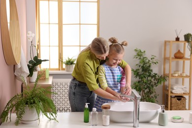 Mother and daughter washing their hands in bathroom