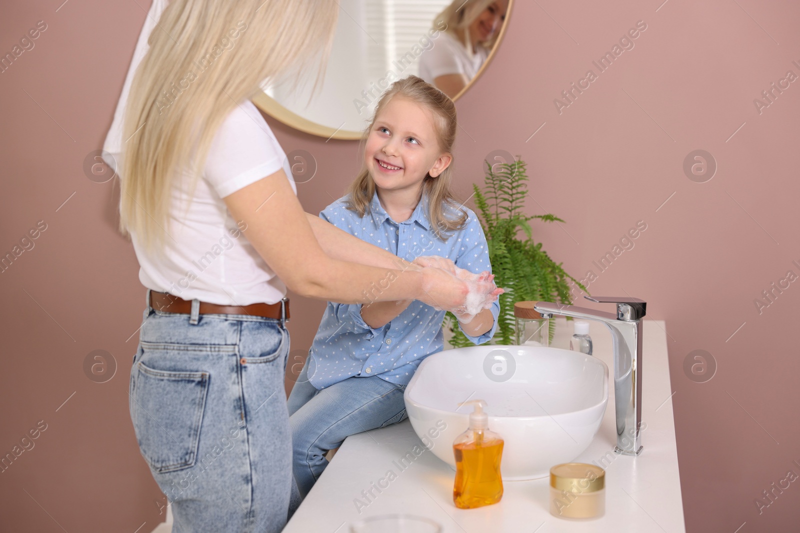 Photo of Happy daughter and mother washing their hands in bathroom