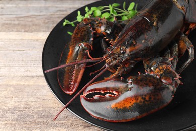 Photo of Raw lobster and microgreens on wooden table, closeup