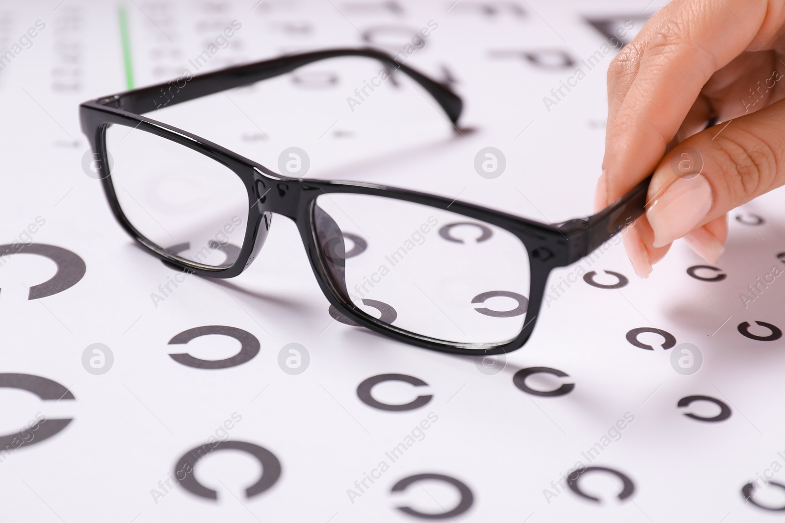 Photo of Woman with glasses and vision test chart, closeup