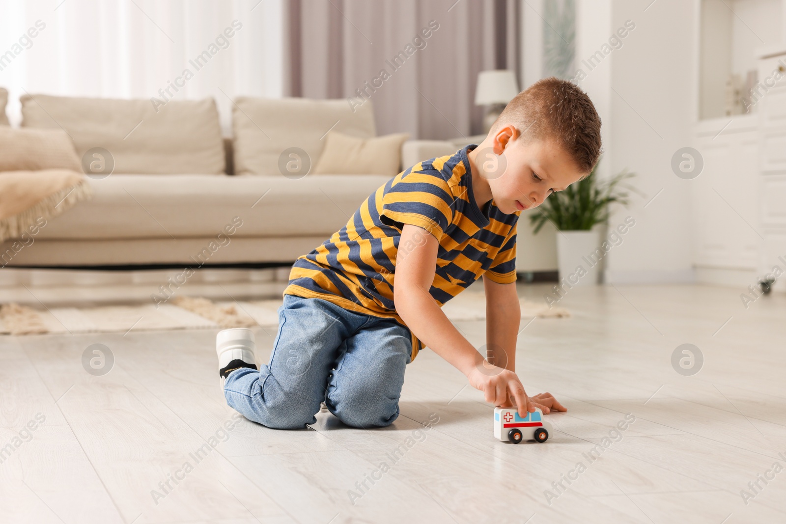 Photo of Little boy playing with toy car at home