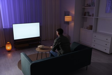 Man watching tv at home in evening