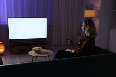 Woman watching tv at home in evening