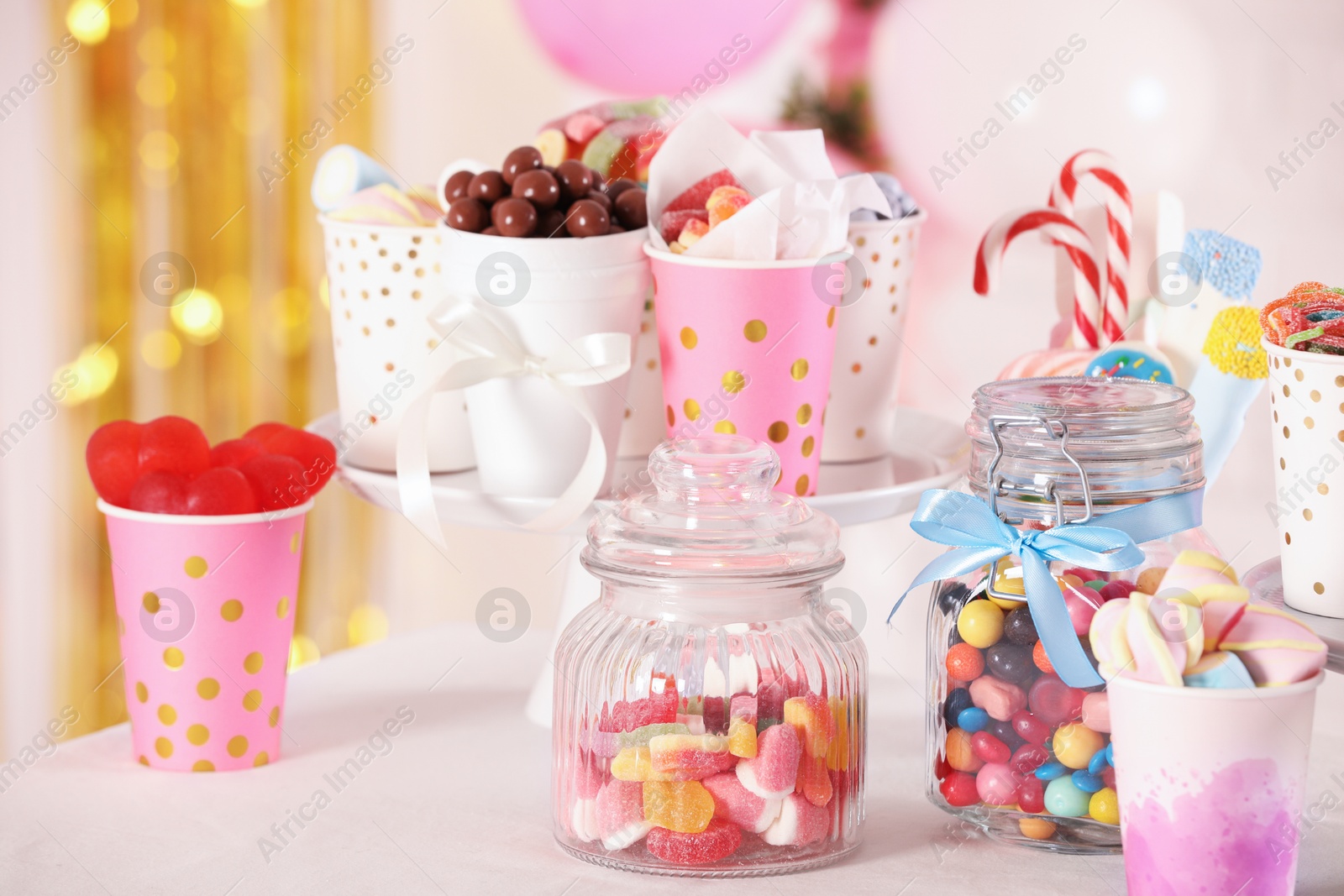 Photo of Candy bar. Many different sweets on table in festive decorated room