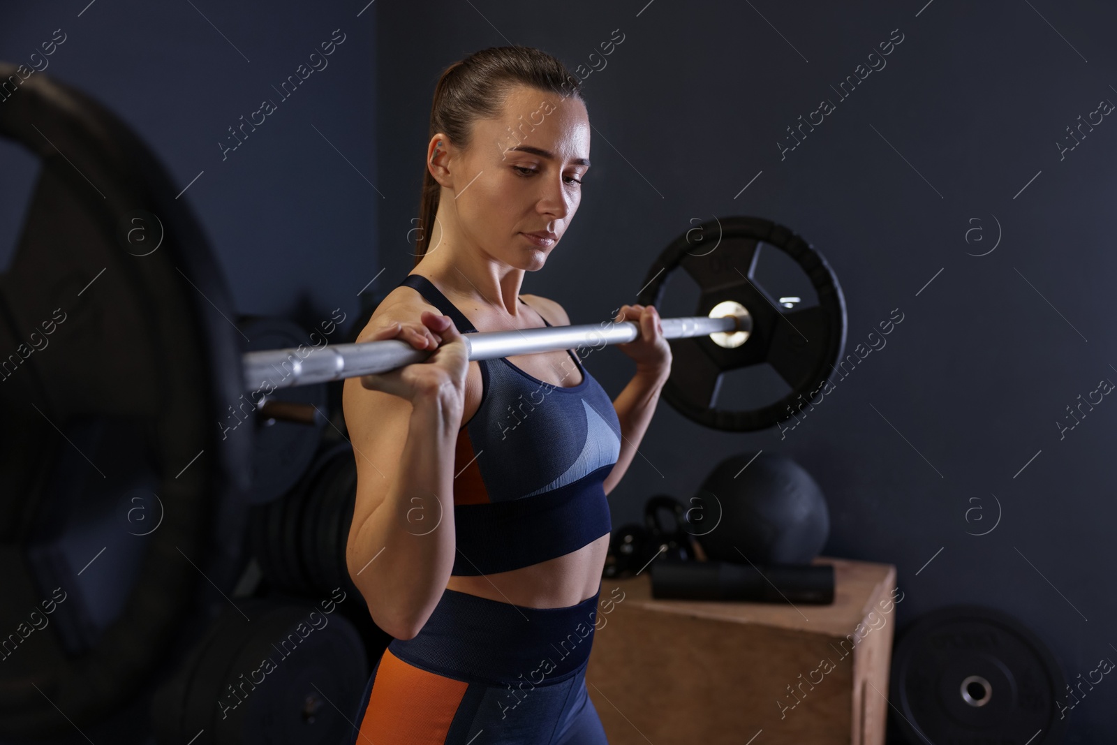 Photo of Sportswoman with barbell during crossfit workout in gym