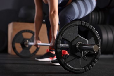 Sportswoman with barbell during crossfit workout in gym, closeup