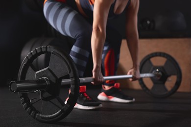 Sportswoman with barbell during crossfit workout in gym, closeup