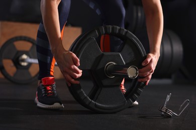 Sportswoman with barbell during crossfit workout in gym, closeup