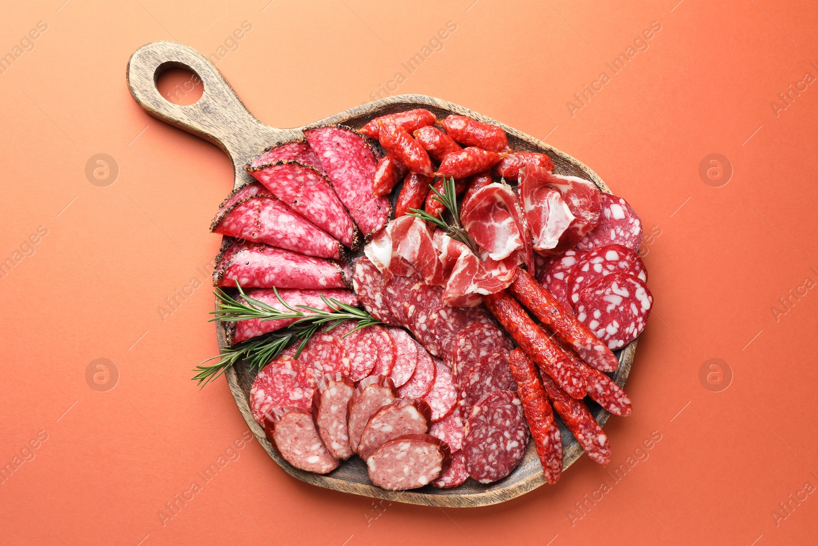 Photo of Different smoked sausages slices on orange background, top view