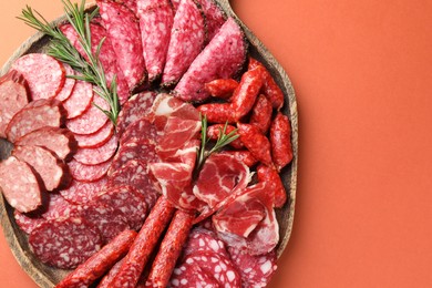 Photo of Different smoked sausages slices on orange background, top view