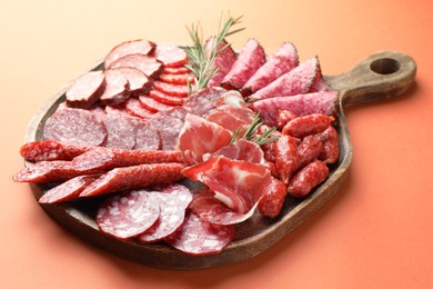 Photo of Different smoked sausages slices on orange background, closeup