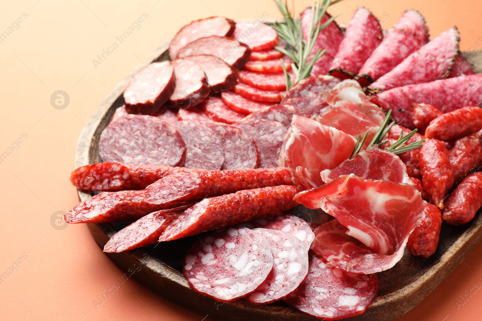 Photo of Different smoked sausages slices on orange background, closeup