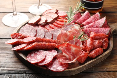 Different smoked sausages slices served on wooden table closeup