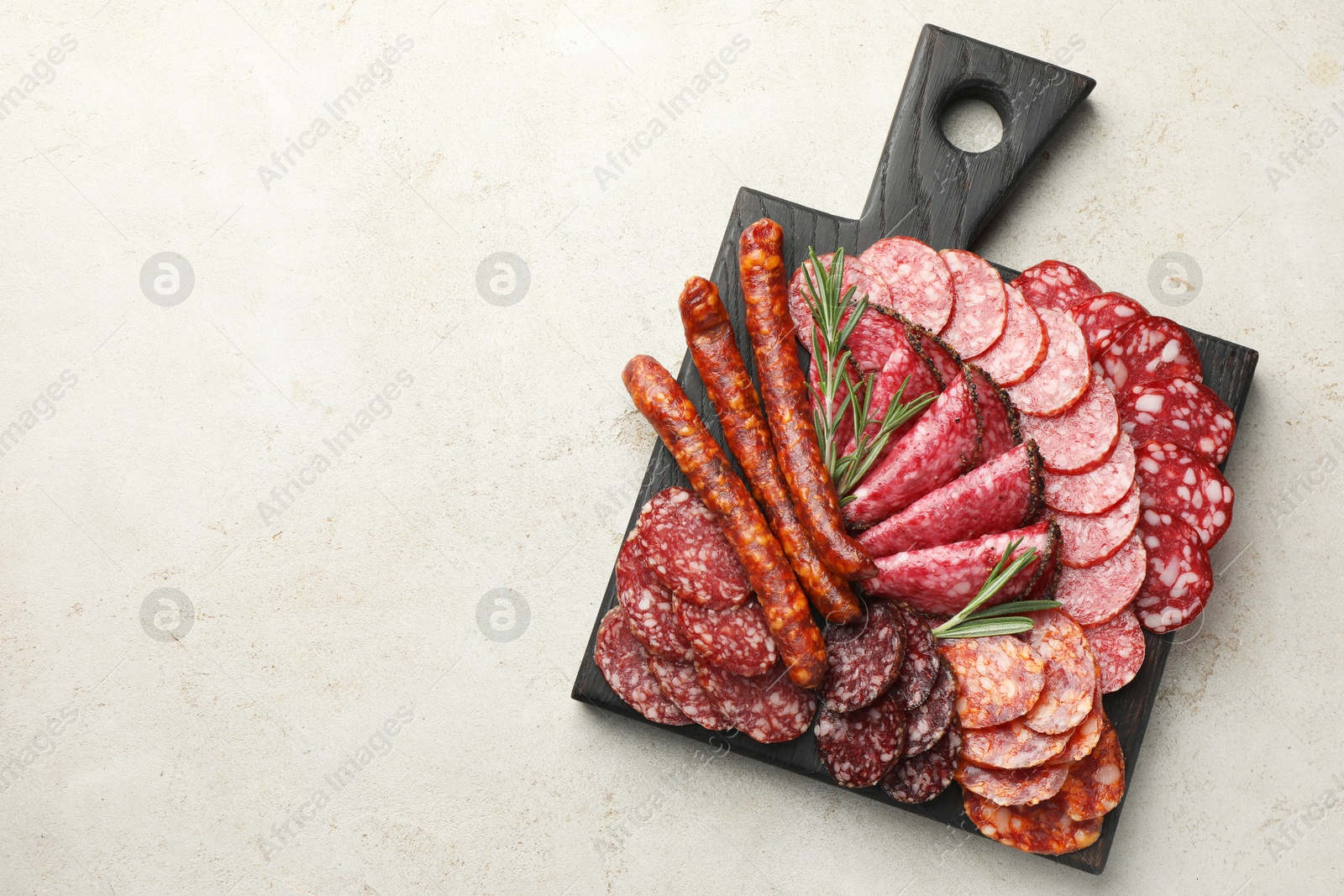 Photo of Different smoked sausages slices served on light table, top view. Space for text