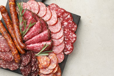 Different smoked sausages slices served on light table, top view