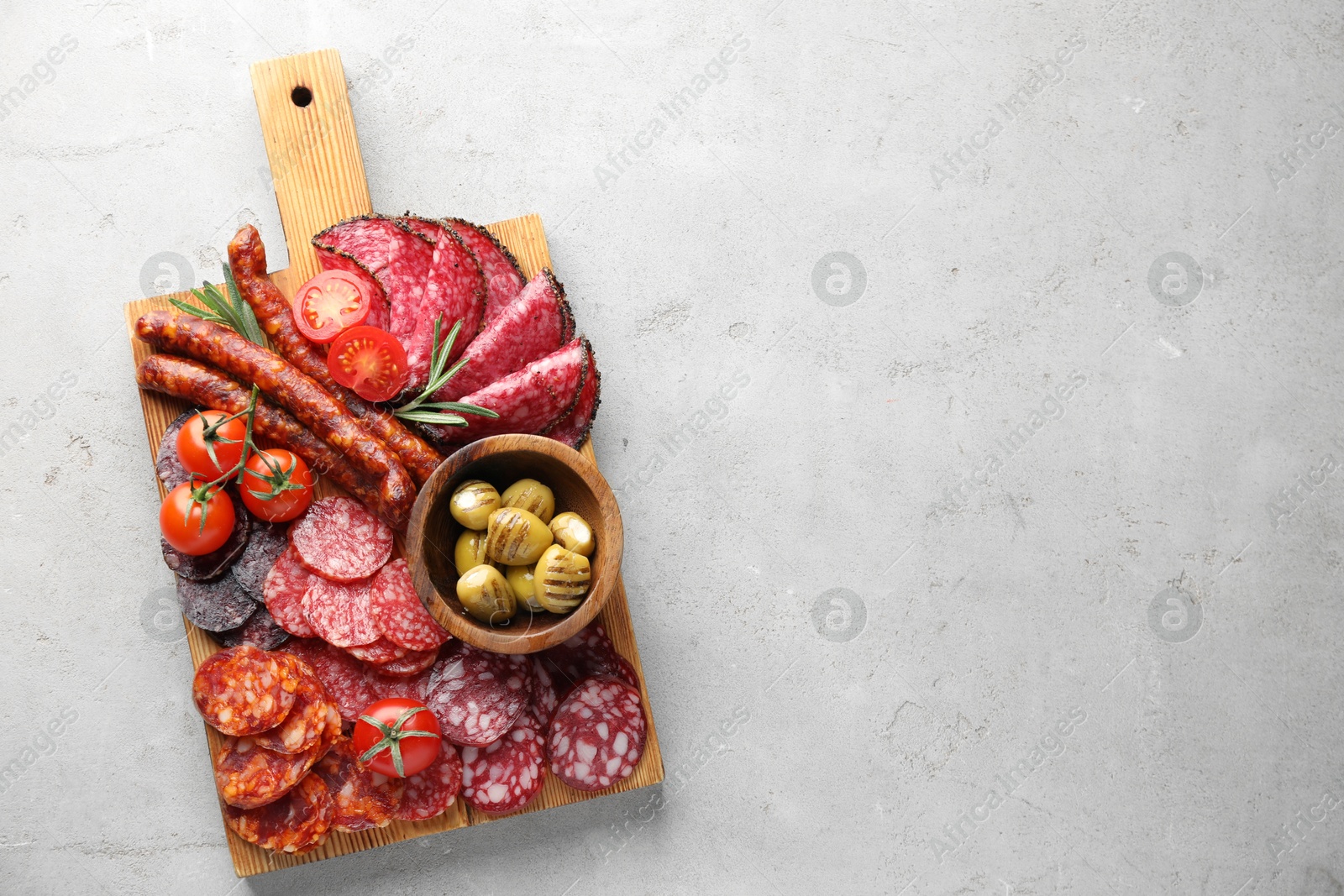 Photo of Different smoked sausages slices served on light table, top view. Space for text