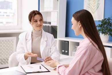 Photo of Gynecologist recommending contraceptive pills to woman in clinic