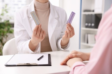 Photo of Gynecologist recommending contraceptive pills to woman in clinic, closeup