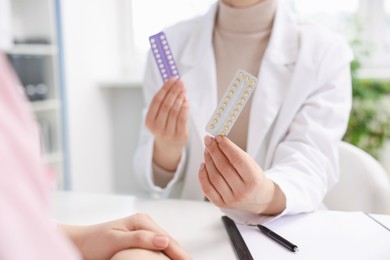 Photo of Gynecologist recommending contraceptive pills to woman in clinic, closeup