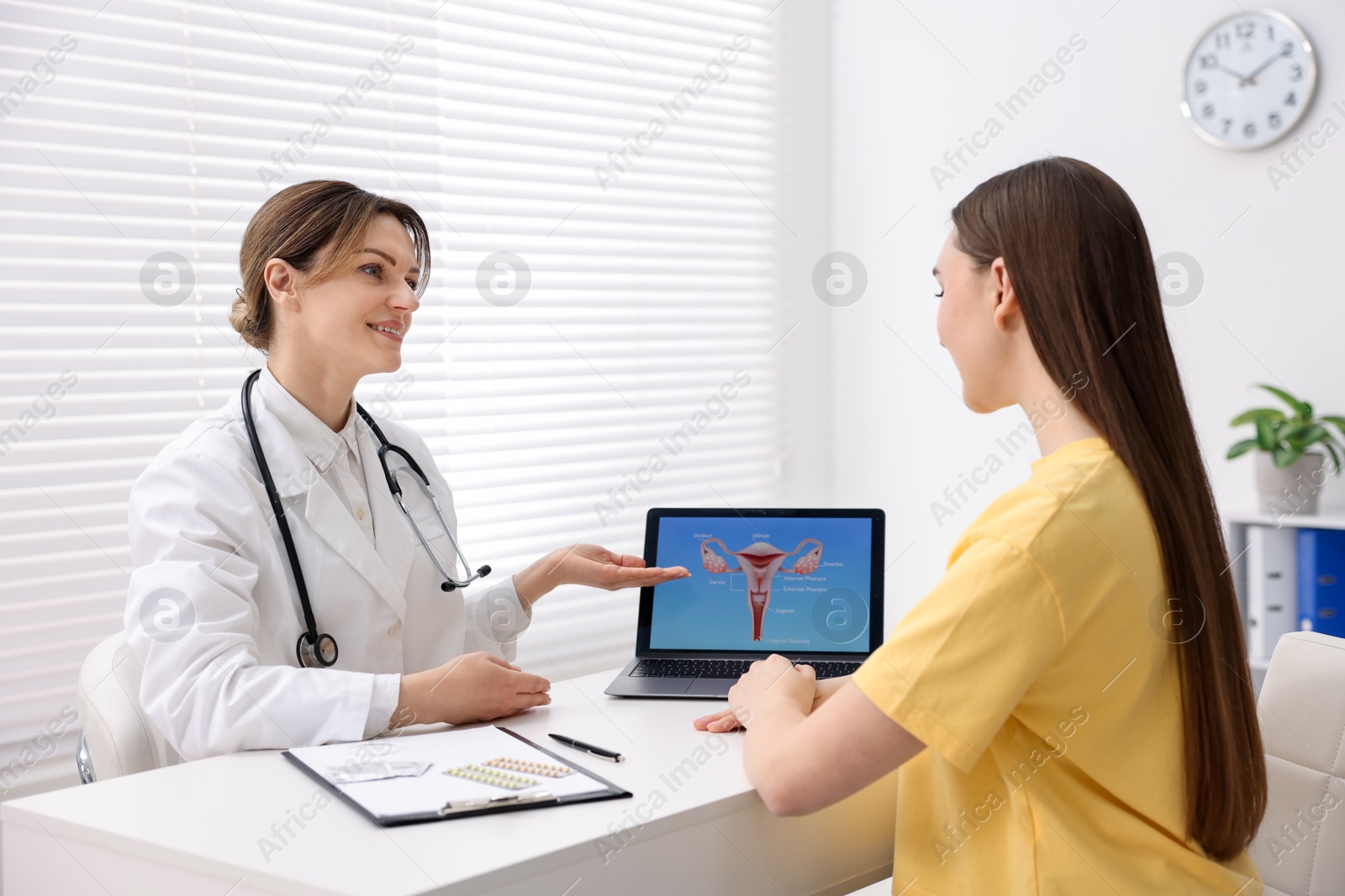 Photo of Contraception. Gynecologist showing image of female reproductive system to woman in clinic