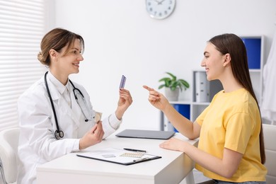 Photo of Gynecologist recommending contraceptive pills to woman in clinic