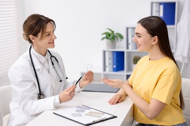 Contraception. Gynecologist recommending vaginal ring to woman in clinic