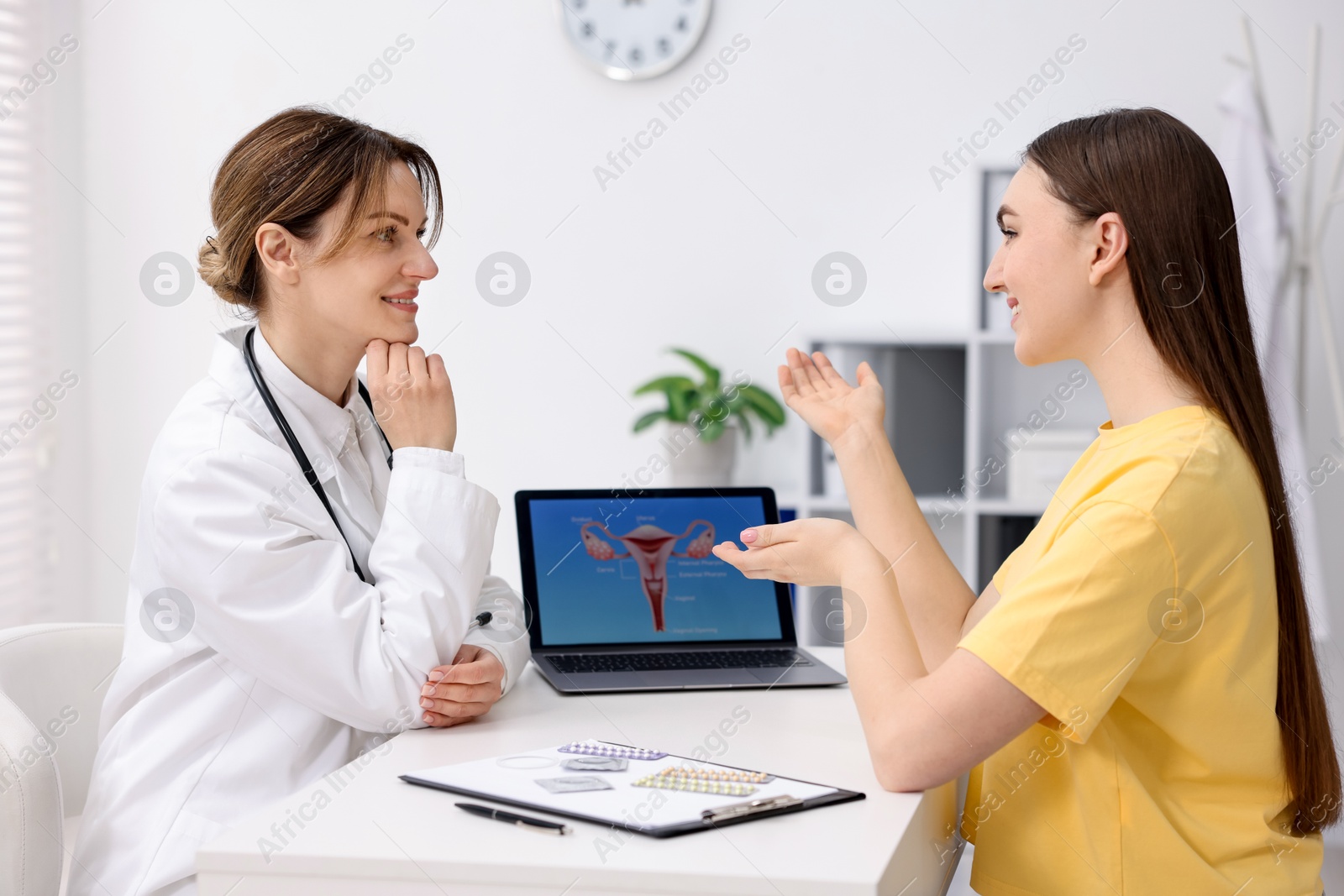 Photo of Contraception. Gynecologist showing image of female reproductive system to woman in clinic