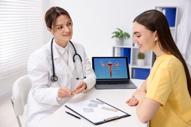 Photo of Gynecologist showing different contraceptive products to woman in clinic