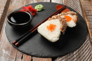 Photo of Tasty onigiri (Japanese rice balls) with tuna served on wooden table, closeup