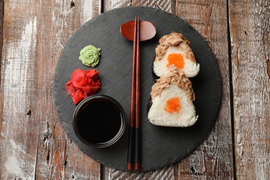 Photo of Tasty onigiri (Japanese rice balls) with tuna served on wooden table, top view