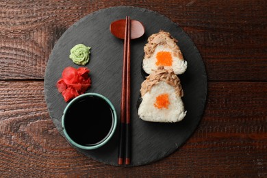 Photo of Tasty onigiri (Japanese rice balls) with tuna served on wooden table, top view