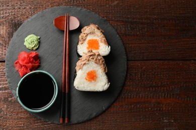 Photo of Tasty onigiri (Japanese rice balls) with tuna served on wooden table, top view. Space for text