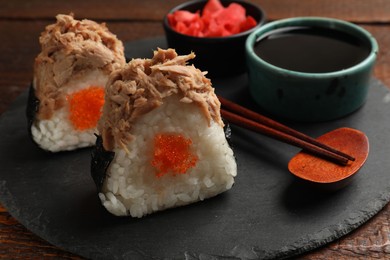 Photo of Tasty onigiri (Japanese rice balls) with tuna served on wooden table, closeup