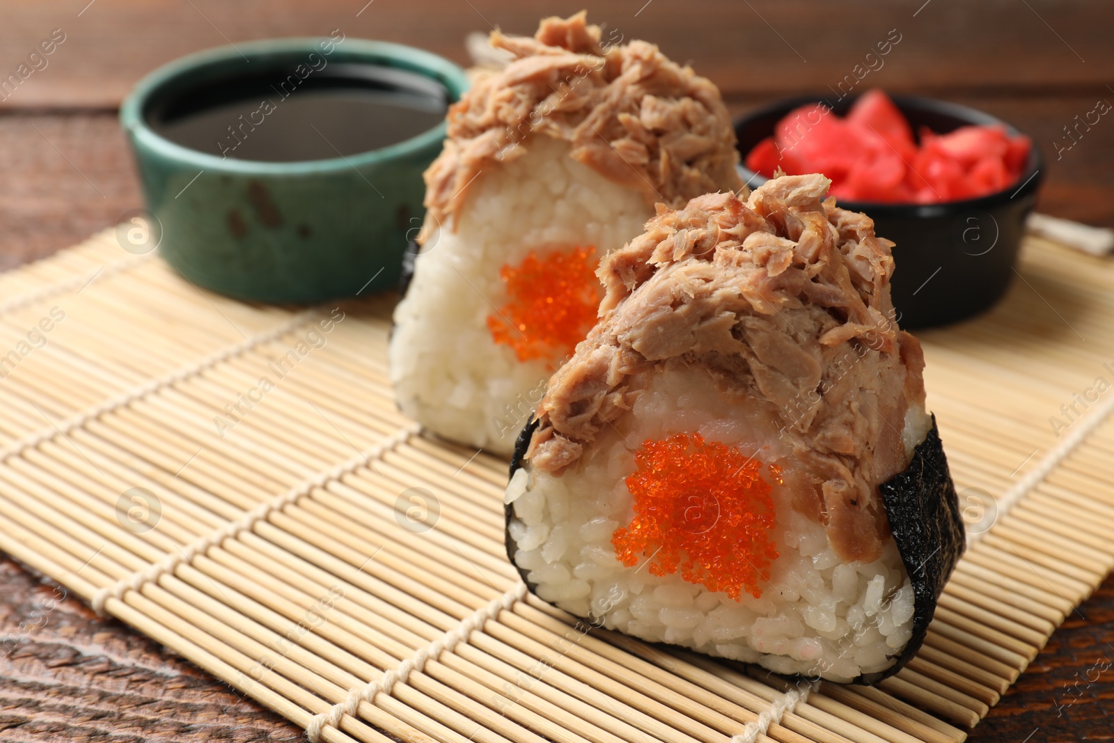 Tasty onigiri (Japanese rice balls) with tuna served on wooden table, closeup Photo of Tasty onigiri (Japanese rice balls) with tuna served on wooden table, closeup