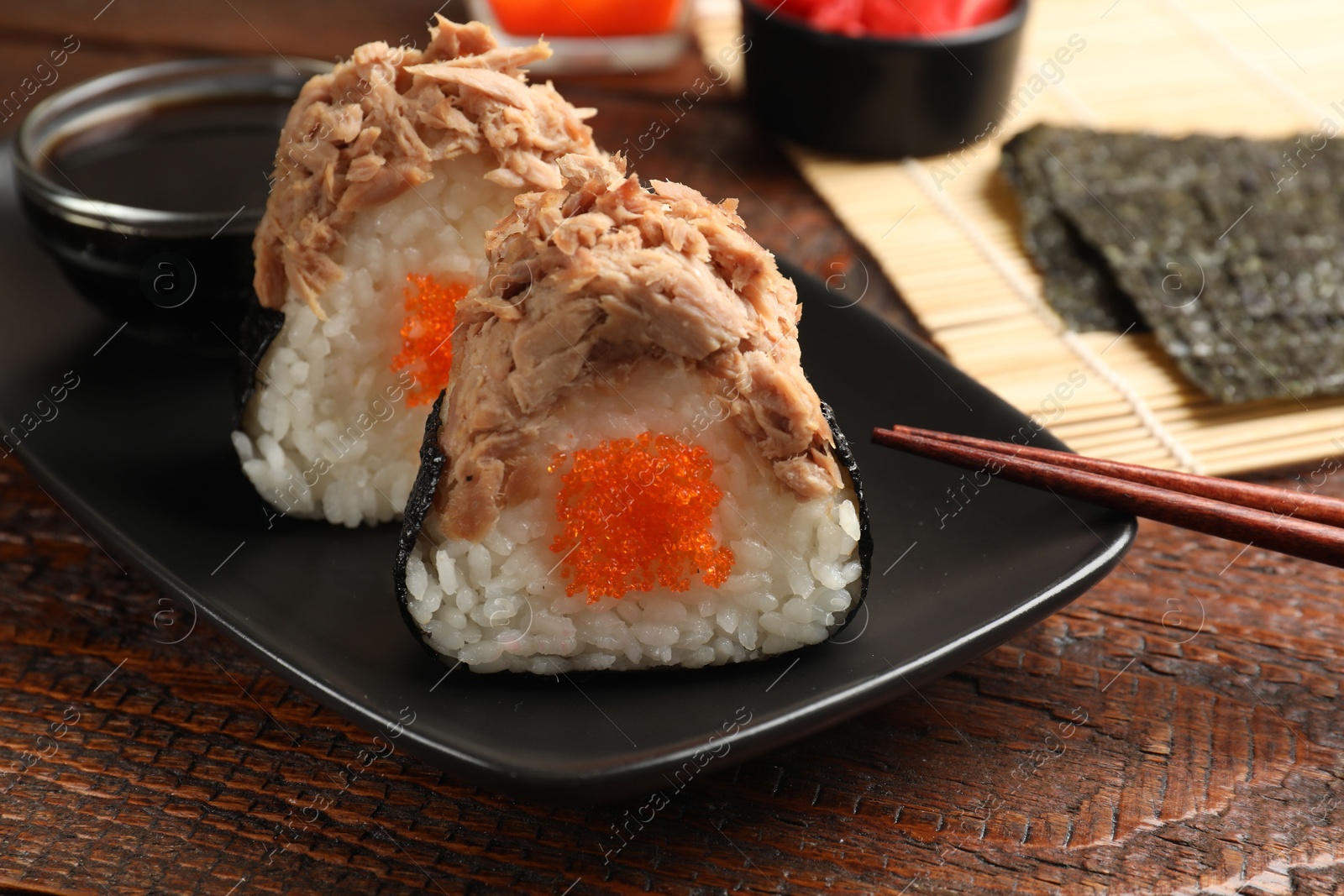 Tasty onigiri (Japanese rice balls) with tuna served on wooden table, closeup Photo of Tasty onigiri (Japanese rice balls) with tuna served on wooden table, closeup
