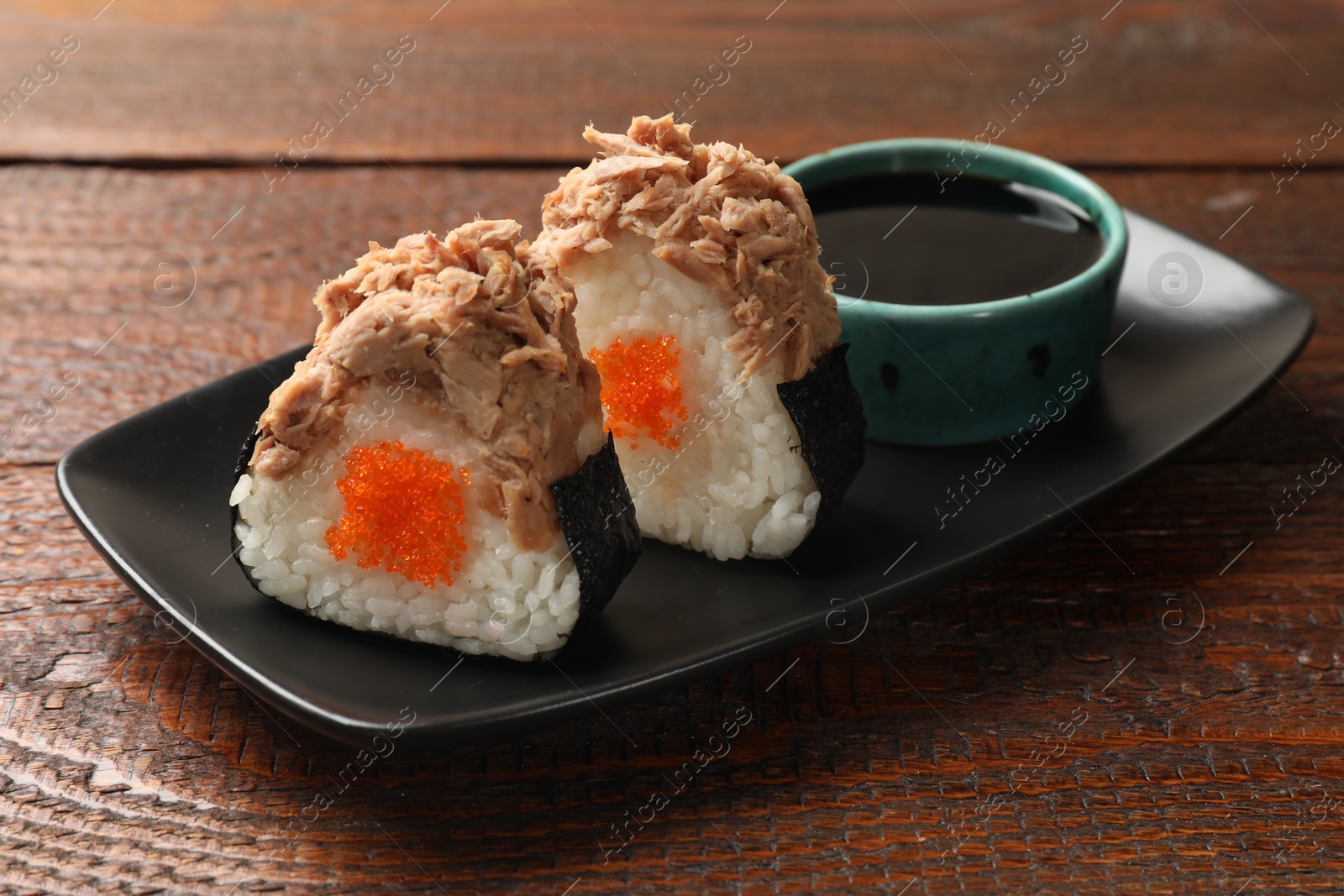 Tasty onigiri (Japanese rice balls) with tuna served on wooden table, closeup Photo of Tasty onigiri (Japanese rice balls) with tuna served on wooden table, closeup