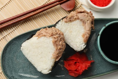 Photo of Tasty onigiri (Japanese rice balls) with tuna served on table, flat lay