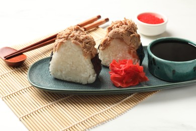 Photo of Tasty onigiri (Japanese rice balls) with tuna served on white table, closeup
