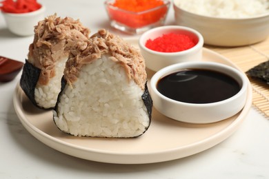 Photo of Tasty onigiri (Japanese rice balls) with tuna served on white marble table, closeup