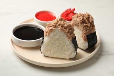 Photo of Tasty onigiri (Japanese rice balls) with tuna served on white marble table, closeup
