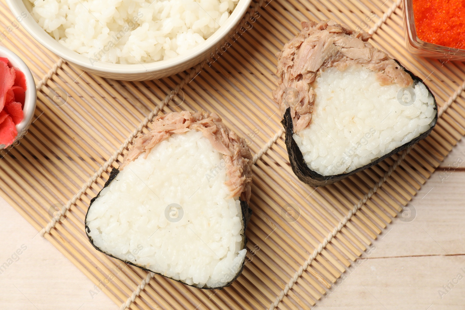 Tasty onigiri (Japanese rice balls) with tuna served on wooden table, flat lay Photo of Tasty onigiri (Japanese rice balls) with tuna served on wooden table, flat lay