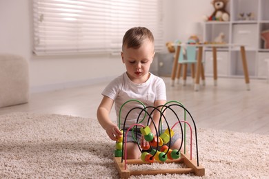 Motor skills development. Little boy playing with toy on floor at home