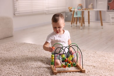 Motor skills development. Little boy playing with toy on floor at home