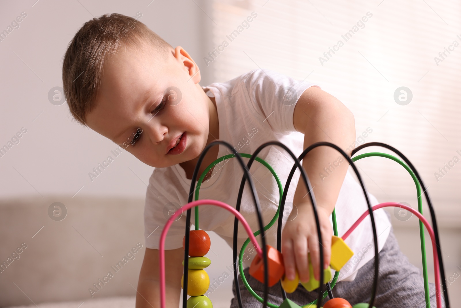 Photo of Motor skills development. Little boy playing with toy at home