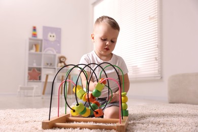 Motor skills development. Little boy playing with toy on floor at home