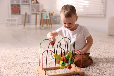 Motor skills development. Little boy playing with toy on floor at home